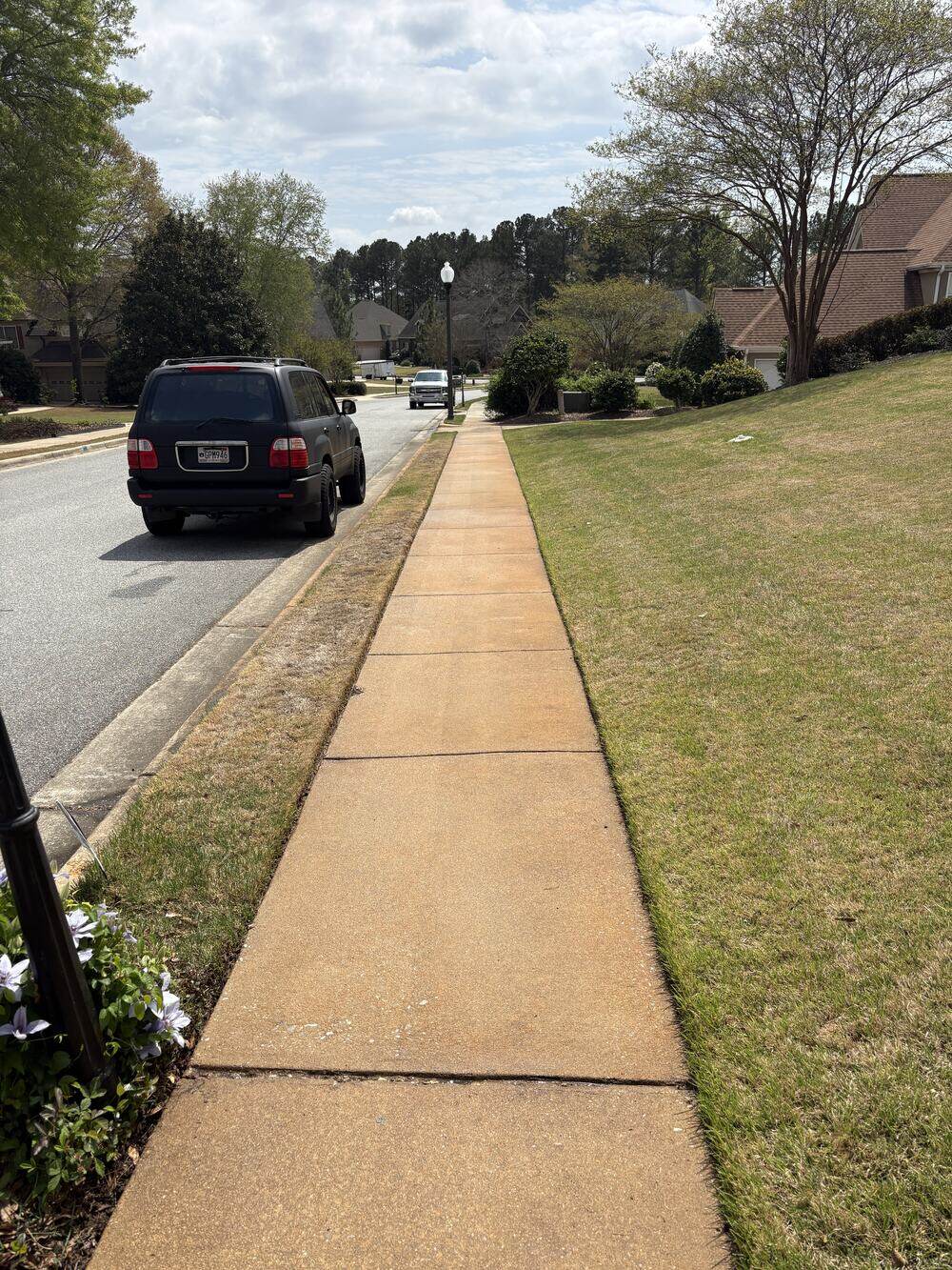 A neighborhood sidewalk after cleaning, restored to a uniform light finish